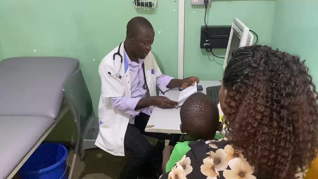 Clinician reviewing a patient's record in a consultation room